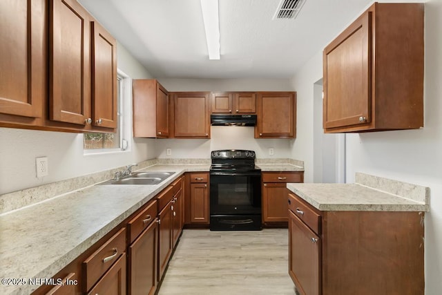 kitchen with light countertops, a sink, light wood-type flooring, black range with electric cooktop, and under cabinet range hood