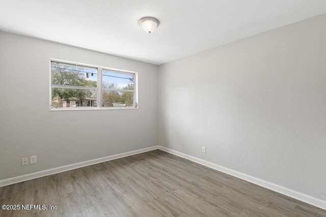 unfurnished room with wood finished floors and baseboards