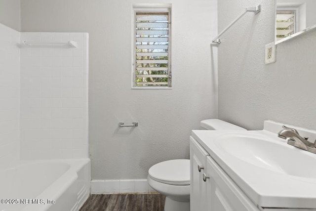 bathroom with baseboards, a textured wall, toilet, wood finished floors, and vanity