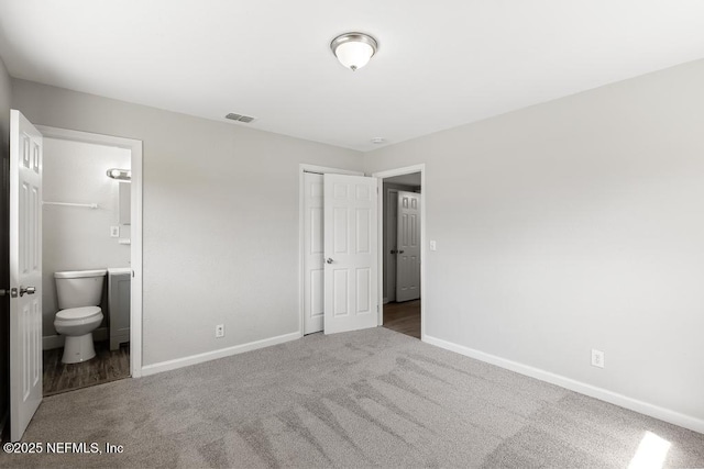 unfurnished bedroom with ensuite bathroom, carpet flooring, visible vents, baseboards, and a closet