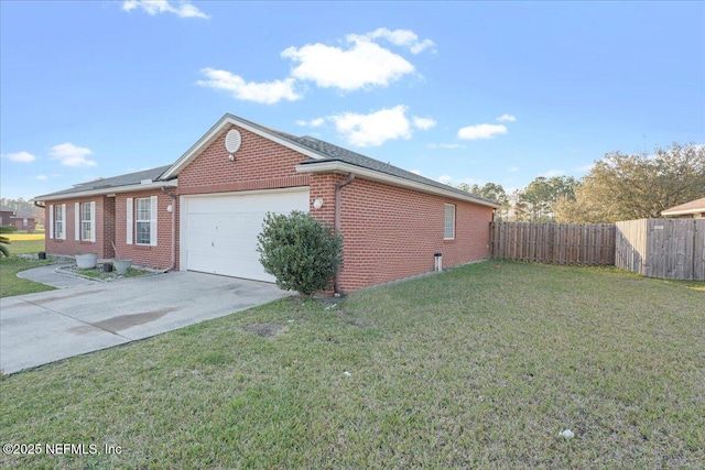 view of side of property featuring driveway, a garage, fence, a yard, and brick siding