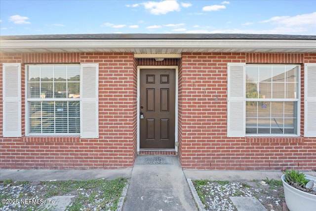 entrance to property featuring brick siding