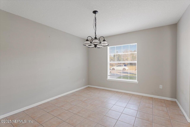 unfurnished room with an inviting chandelier, light tile patterned floors, baseboards, and a textured ceiling