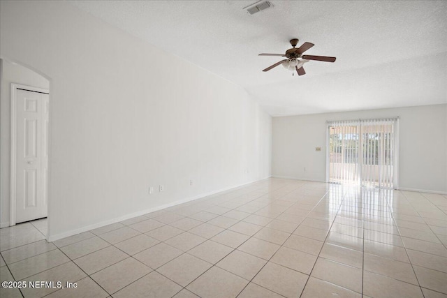 spare room featuring light tile patterned floors, visible vents, ceiling fan, vaulted ceiling, and a textured ceiling