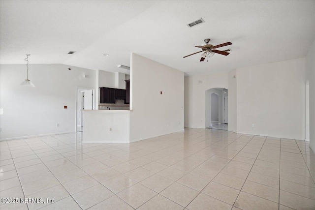 unfurnished living room featuring arched walkways, light tile patterned floors, visible vents, a ceiling fan, and vaulted ceiling