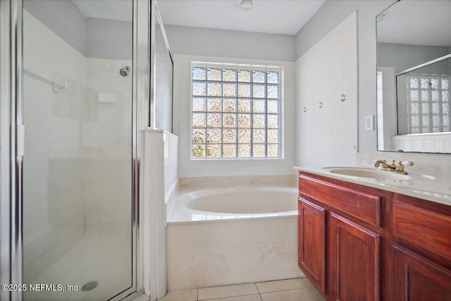 full bath featuring a stall shower, tile patterned flooring, a bath, and vanity