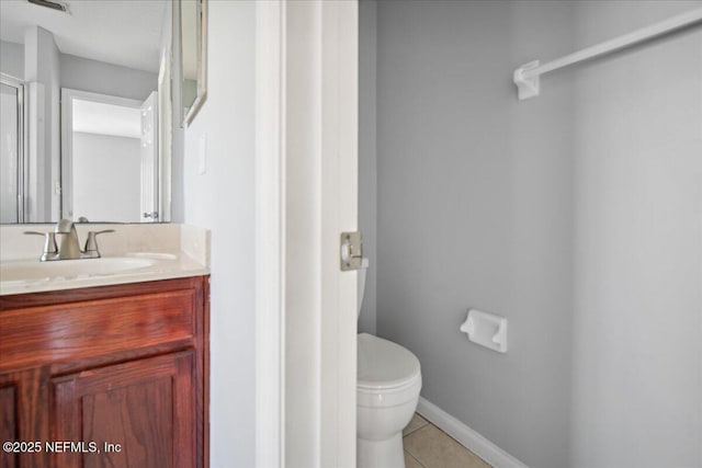 bathroom featuring baseboards, vanity, toilet, and tile patterned floors