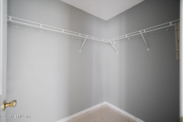 walk in closet featuring light tile patterned flooring