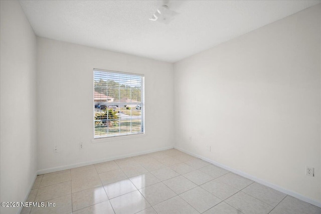 empty room with light tile patterned flooring and baseboards