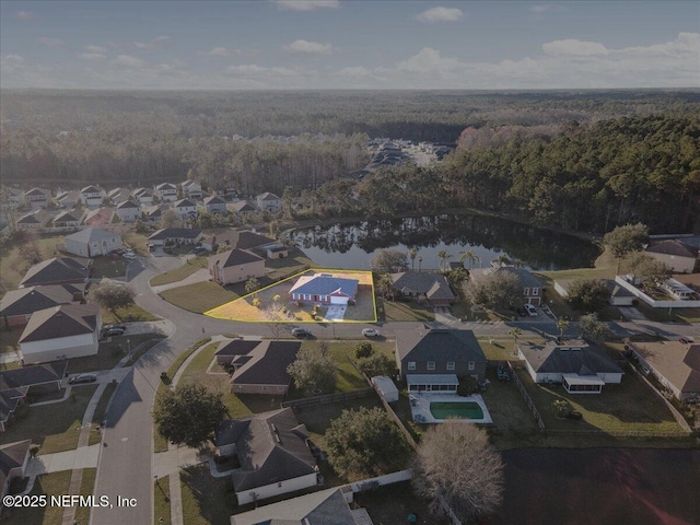 drone / aerial view with a residential view, a water view, and a forest view