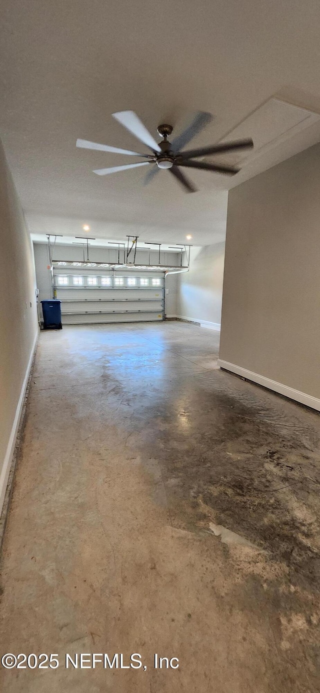 garage featuring baseboards and ceiling fan
