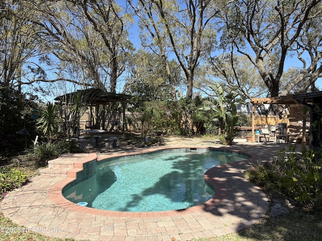 pool featuring a patio, fence, and a pergola