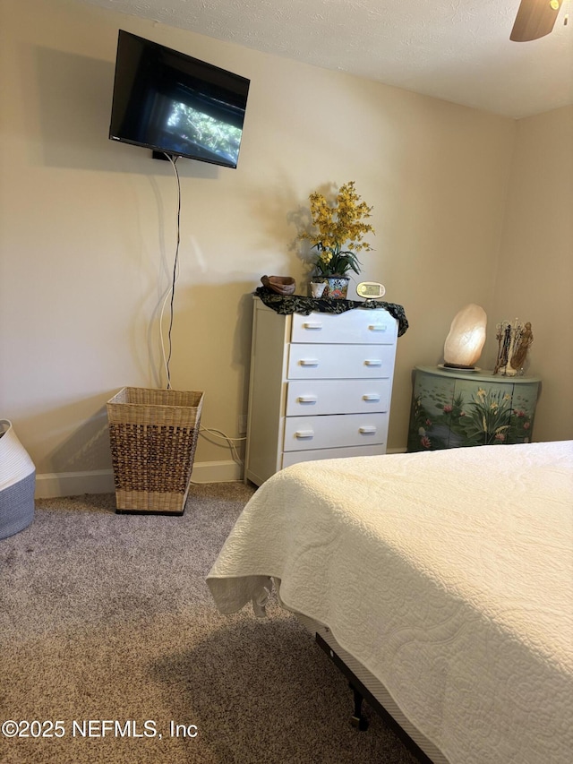 carpeted bedroom featuring baseboards and a ceiling fan