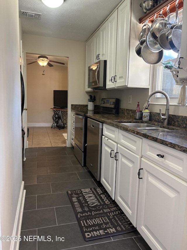 kitchen featuring a sink, visible vents, appliances with stainless steel finishes, and white cabinets