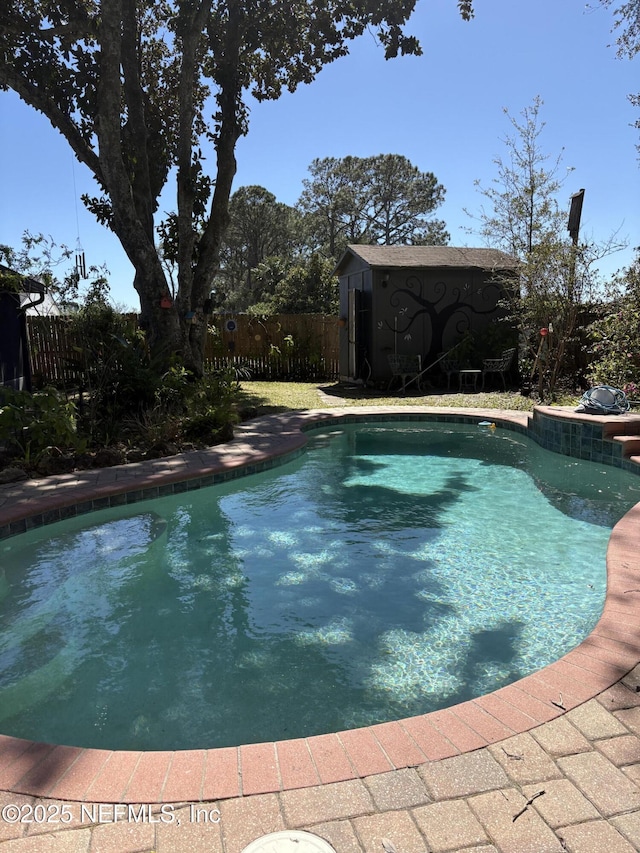 view of swimming pool with an outbuilding, a fenced in pool, a shed, and fence private yard