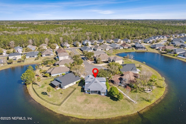 aerial view with a view of trees, a residential view, and a water view