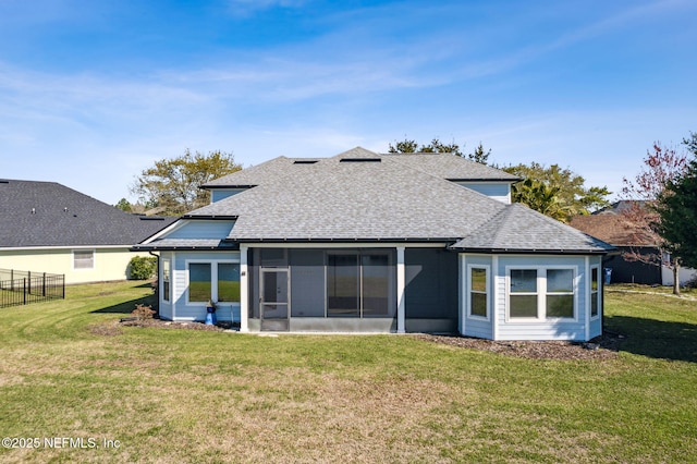 rear view of property featuring a sunroom, a yard, fence, and roof with shingles