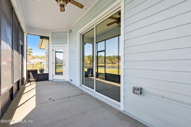 unfurnished sunroom featuring ceiling fan