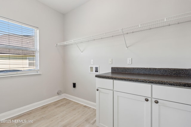 clothes washing area featuring light wood finished floors, cabinet space, baseboards, and washer hookup