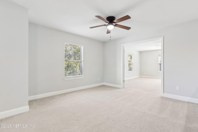 unfurnished room featuring plenty of natural light, light colored carpet, and baseboards