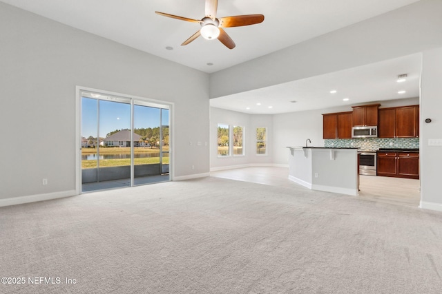 unfurnished living room with recessed lighting, light colored carpet, baseboards, and ceiling fan