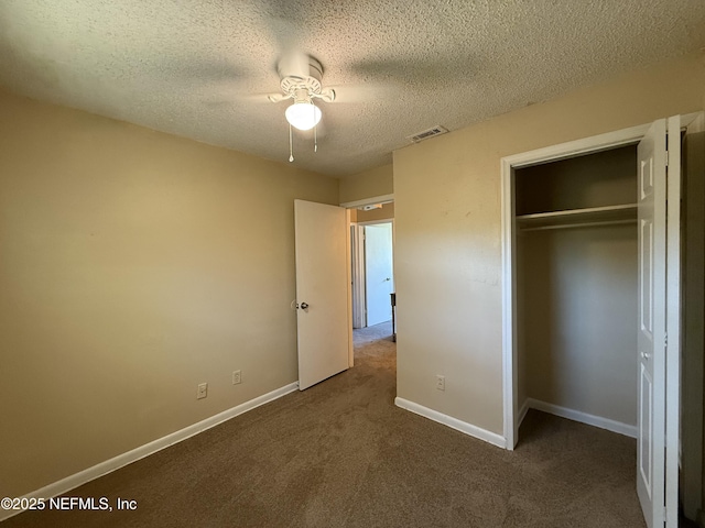 unfurnished bedroom with baseboards, visible vents, a textured ceiling, carpet flooring, and a closet