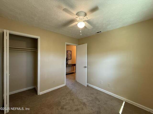 unfurnished bedroom with carpet floors, a closet, visible vents, and baseboards