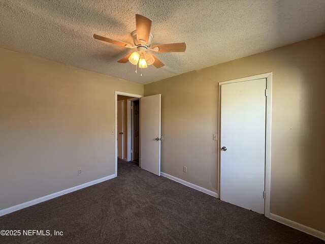 unfurnished bedroom with ceiling fan, baseboards, a textured ceiling, and carpet flooring