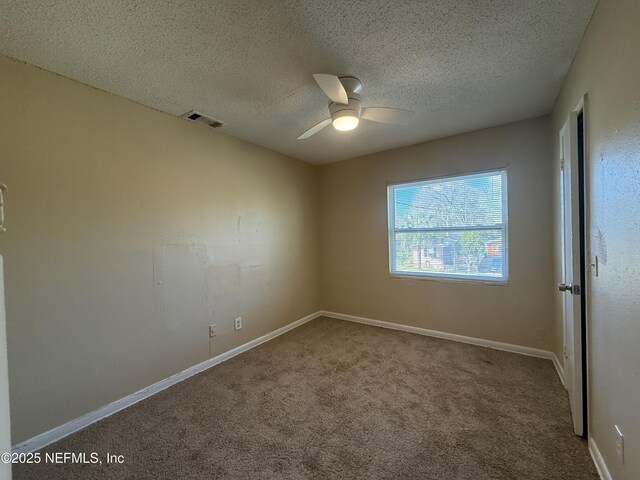 unfurnished room featuring carpet, visible vents, a textured ceiling, and baseboards