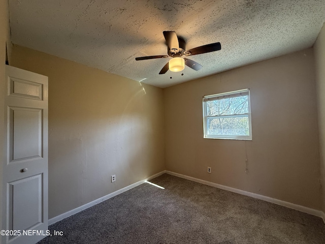 unfurnished room featuring carpet floors, a textured ceiling, baseboards, and a ceiling fan