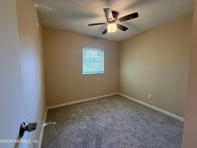 carpeted spare room featuring ceiling fan, a textured ceiling, and baseboards