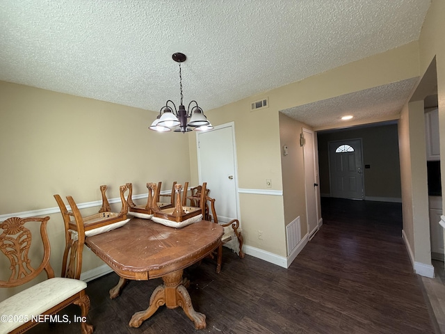 dining area with baseboards, visible vents, wood finished floors, an inviting chandelier, and a textured ceiling