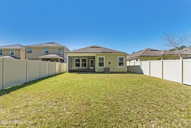 rear view of house with a fenced backyard, cooling unit, and a lawn