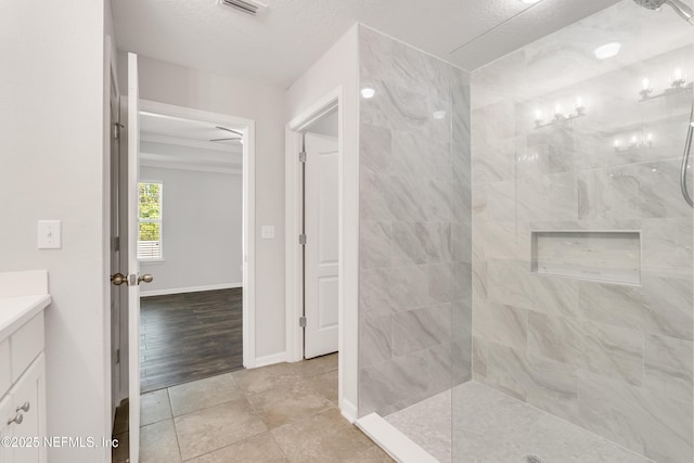 full bathroom with visible vents, vanity, baseboards, and a walk in shower