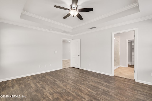 interior space featuring wood finished floors, a raised ceiling, visible vents, and baseboards