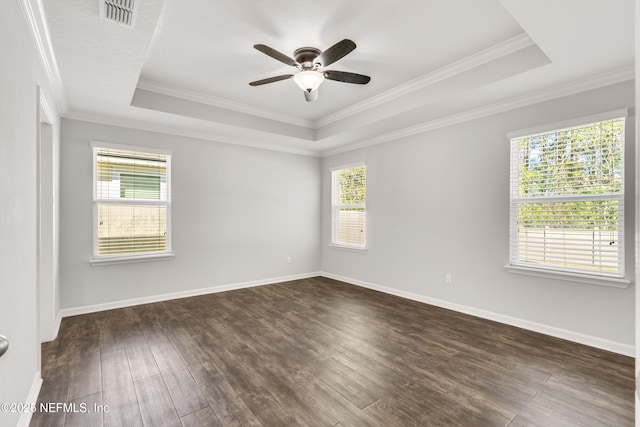 empty room featuring a raised ceiling, baseboards, crown molding, and dark wood-style flooring