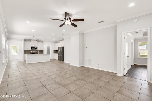 unfurnished living room with ornamental molding, a ceiling fan, visible vents, and light tile patterned floors