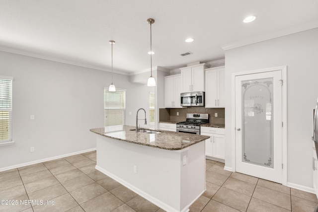 kitchen featuring visible vents, backsplash, appliances with stainless steel finishes, ornamental molding, and a sink