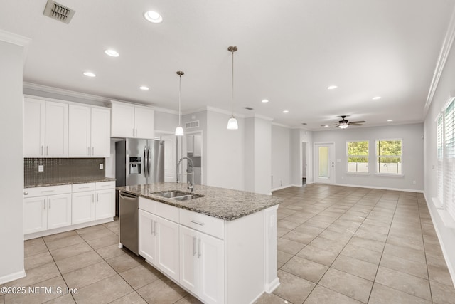 kitchen featuring appliances with stainless steel finishes, a sink, decorative backsplash, and ornamental molding