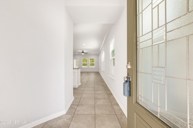 hallway with light tile patterned floors and baseboards