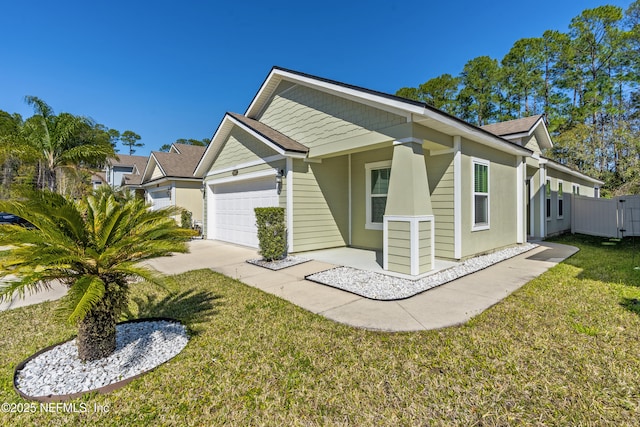 view of front of house featuring a garage, fence, concrete driveway, and a front yard