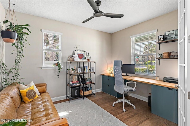 home office featuring a textured ceiling, light wood-style floors, and a healthy amount of sunlight