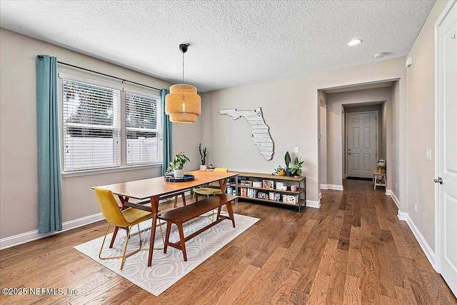 dining space featuring recessed lighting, a textured ceiling, baseboards, and wood finished floors