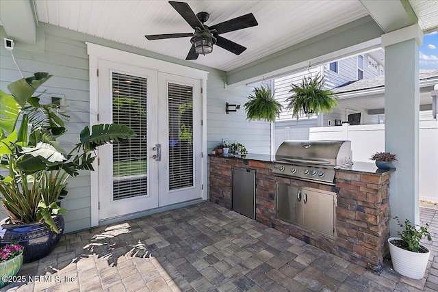 view of patio / terrace with area for grilling, a ceiling fan, fence, french doors, and grilling area