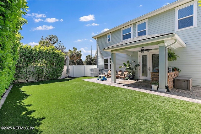 back of property with a patio area, a yard, a fenced backyard, and ceiling fan