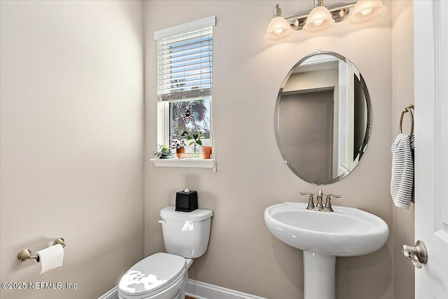 bathroom featuring toilet and baseboards