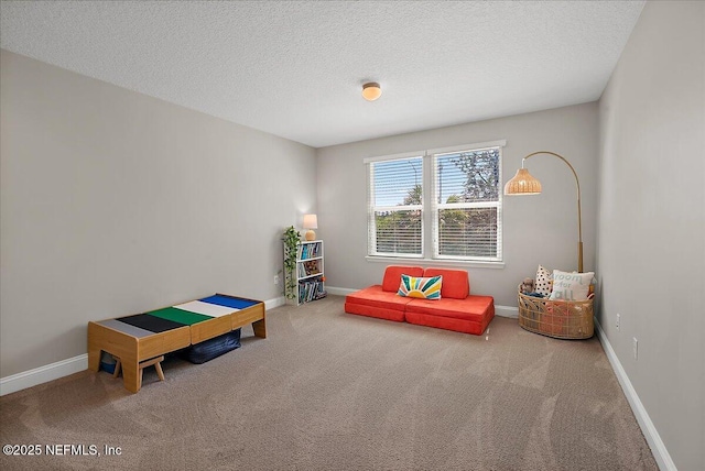 game room featuring carpet flooring, baseboards, and a textured ceiling