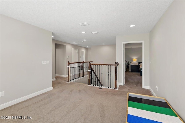 interior space featuring baseboards, carpet floors, an upstairs landing, recessed lighting, and a textured ceiling