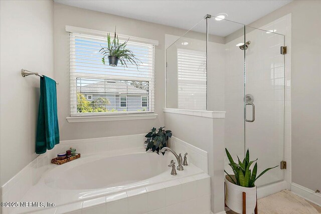 bathroom with a stall shower, plenty of natural light, and a bath