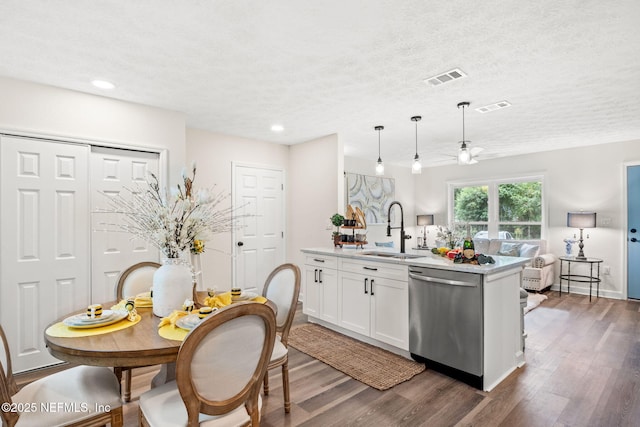 kitchen featuring dishwasher, light countertops, visible vents, and a sink